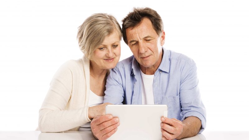 Senior couple using tablet, isolated on white background